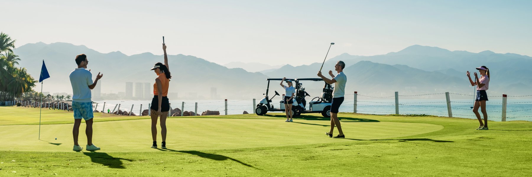 Golfistas jugando con el campo de golf de fondo en Granv Velas